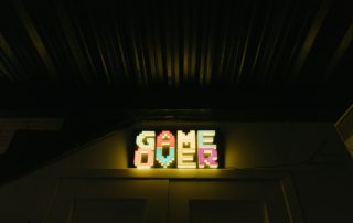 a light up game over sign in a dark room