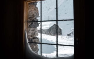 looking out of a cabin window to a snowy landscape